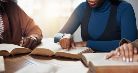 People praying together around a Bible