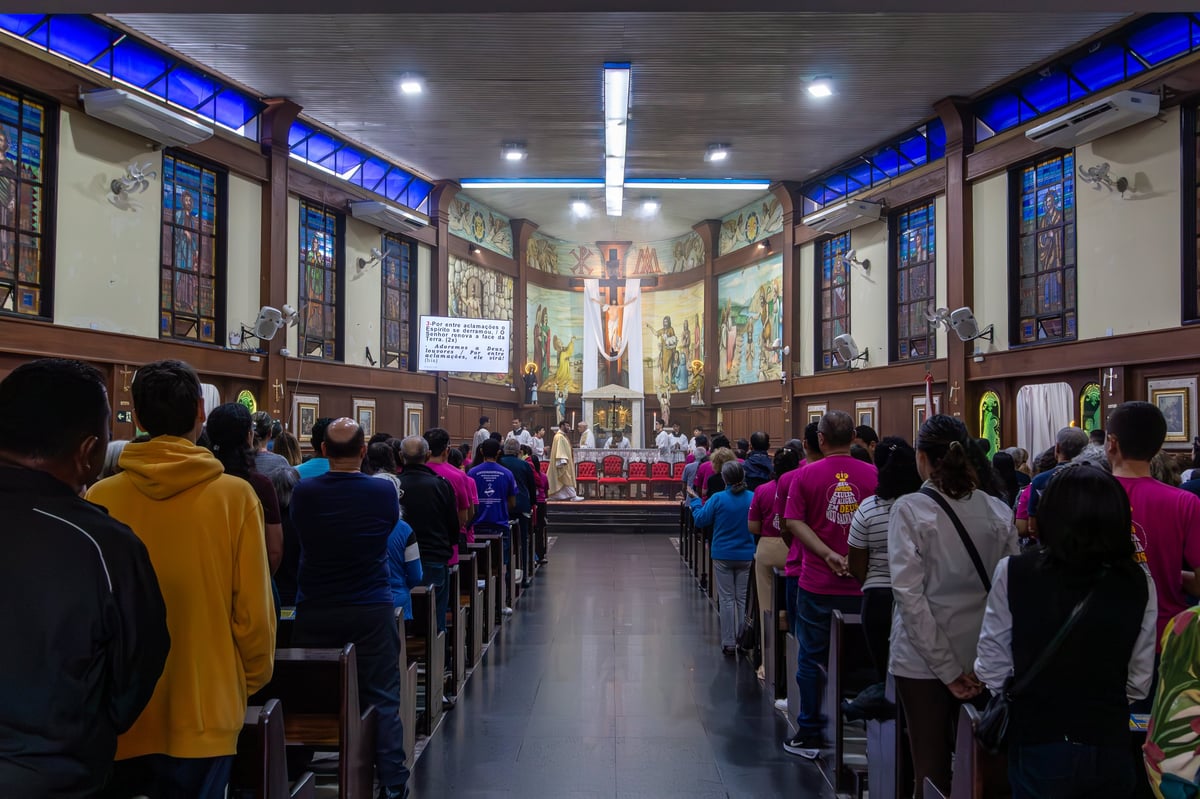 Diverse churchgoers clap and sing in pews during uplifting sunday service