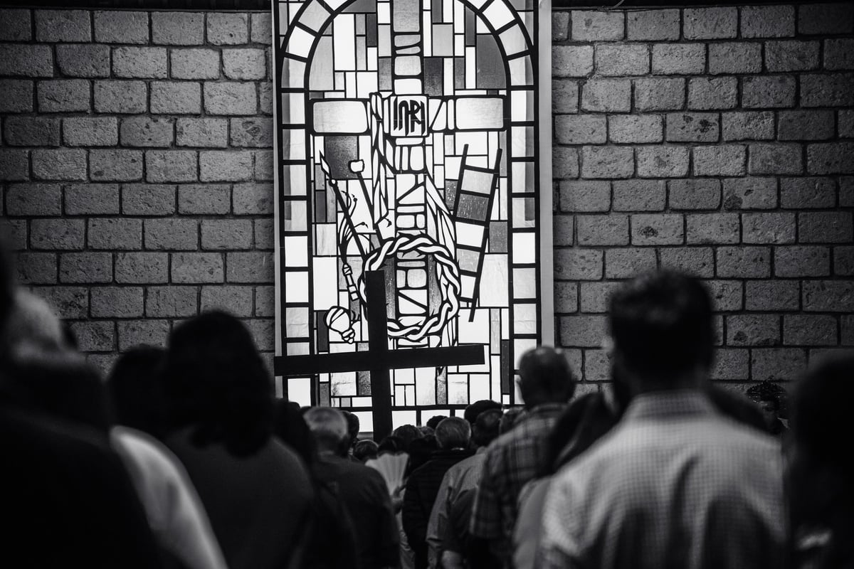 A line of catholics-christians walking to a cross