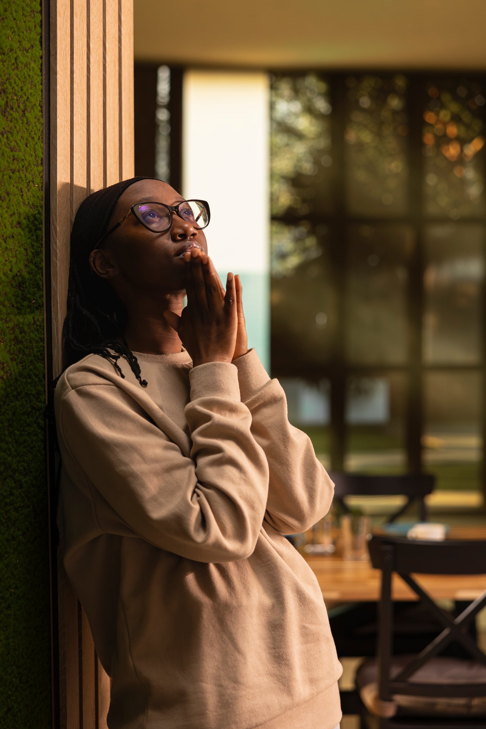 African american girl, hands in a prayer, praying at home, showing belief and devotion to God. Person with faith and sacred gratitude communicating with Jesus Christ, spiritual sacred connection.